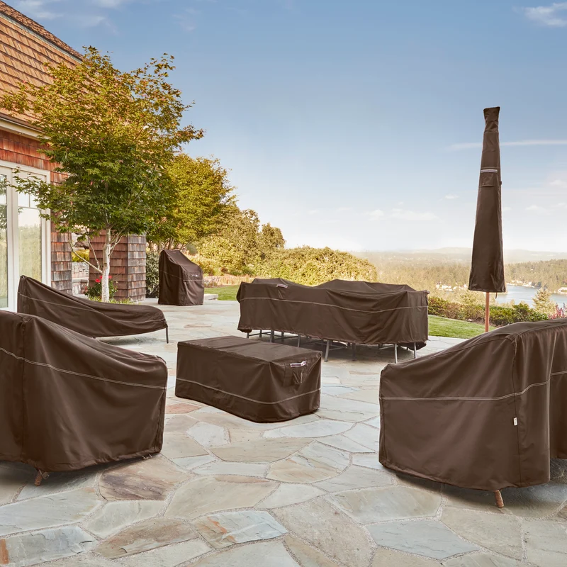 Blueridge patio furniture covers protecting an outdoor dining set, chairs and parasol